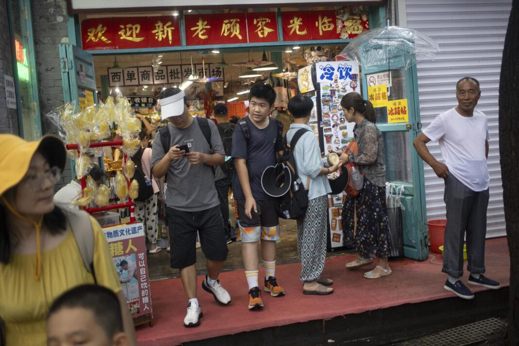 Beijing (China), 15/08/2024.- People walk out of a store at a street in Beijing, China, 15 August 2024. China's retail sales grew by 2.7 percent in July 2024. EFE/EPA/ANDRES MARTINEZ CASARES